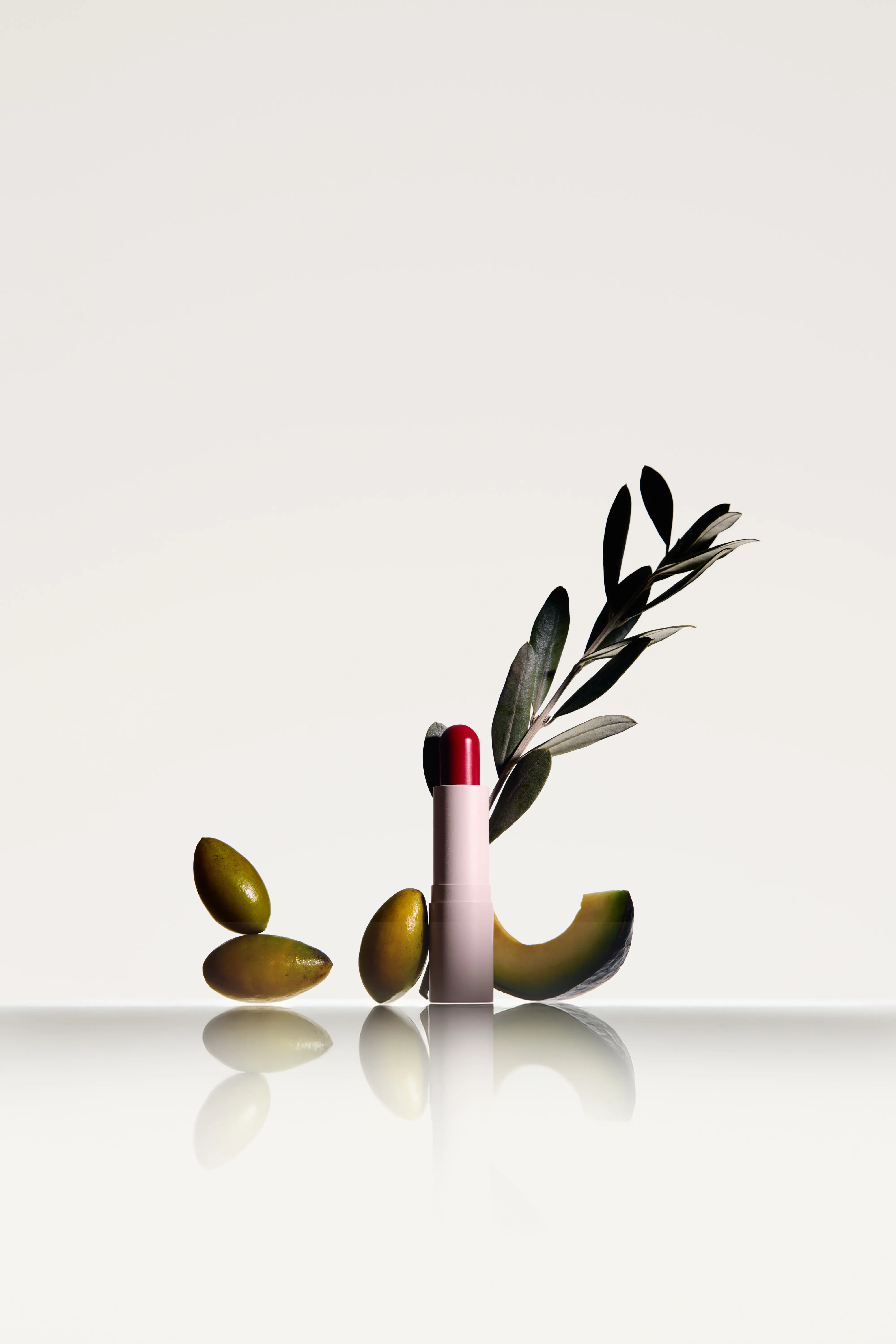 Natural — lipstick beside olive branch and avocado